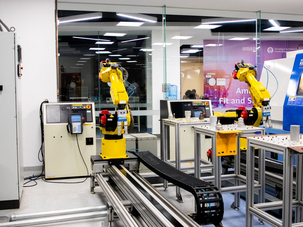 hero-img-02 Robotic arms in action within a modern industrial control room setting, showcasing technology and production.